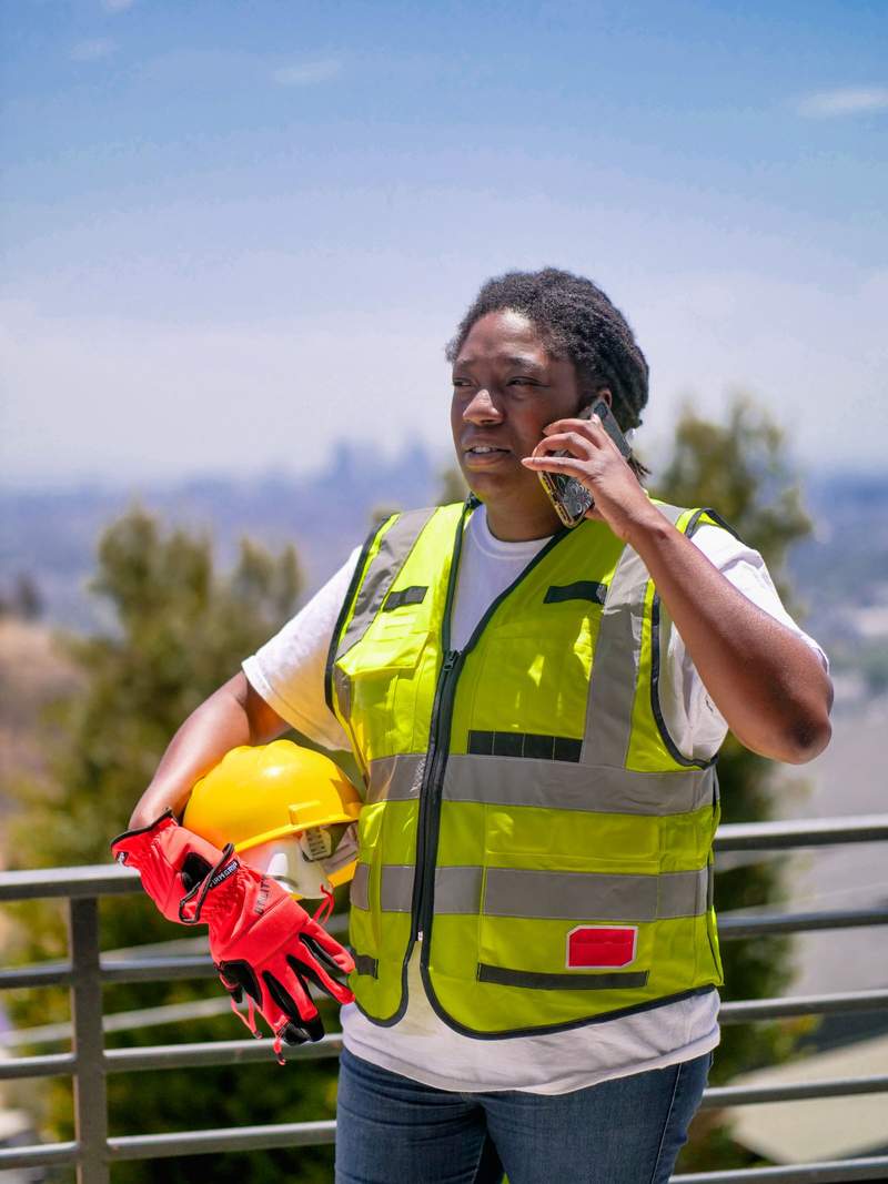 A tradesperson on a job site speaking on a mobile phone